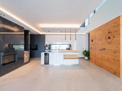 Kuchyňská linka s lakovanými dvířky v kombinaci s dubovou dýhou a kamennou pracovní deskou