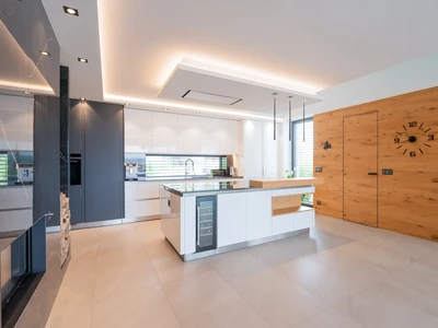 Kuchyňská linka s lakovanými dvířky v kombinaci s dubovou dýhou a kamennou pracovní deskou